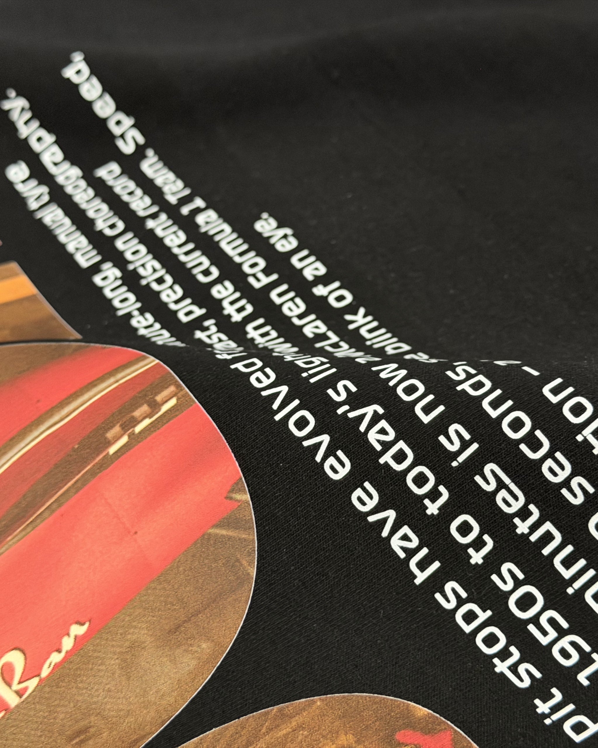 Black unisex T-shirt with white typographic text graphic across shoulder area