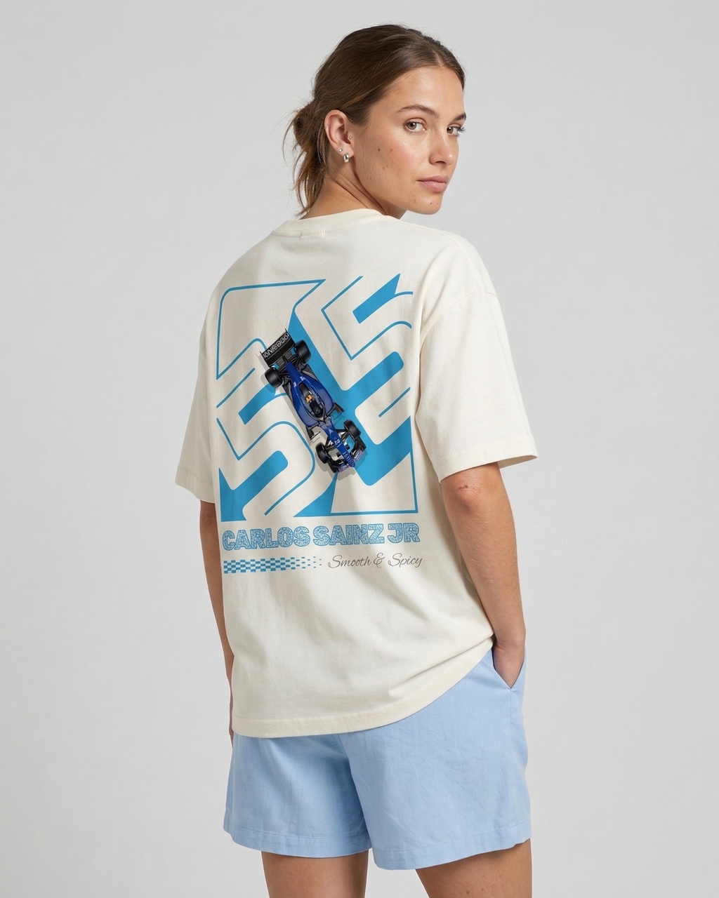 Female Model wearing F1 Turn1 India Off White  oversized unisex tshirt - fan graphic of Carlos Sainz Smooth Operator, Williams F1 raacing team driver and featuring his Car Number 55.
Front print featuring quote - Vamos Sainz