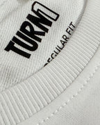 Close-up of F1 Turn1 India White crop top with “SMOOTH OPERATOR” graphic on the front based on driver Carlos Sainz Jr - driver of Williams F1 Racing team
Ribbed crew neck and “SMOOTH OPERATOR” logo detail on white crop top