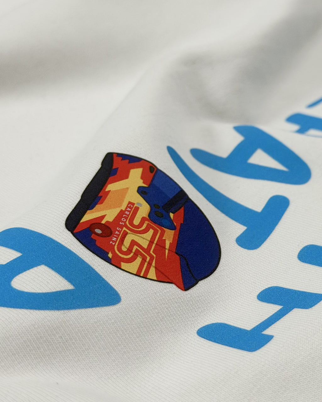 Close-up of F1 Turn1 India White crop top with “SMOOTH OPERATOR” graphic on the front based on driver Carlos Sainz Jr - driver of Williams F1 Racing team
