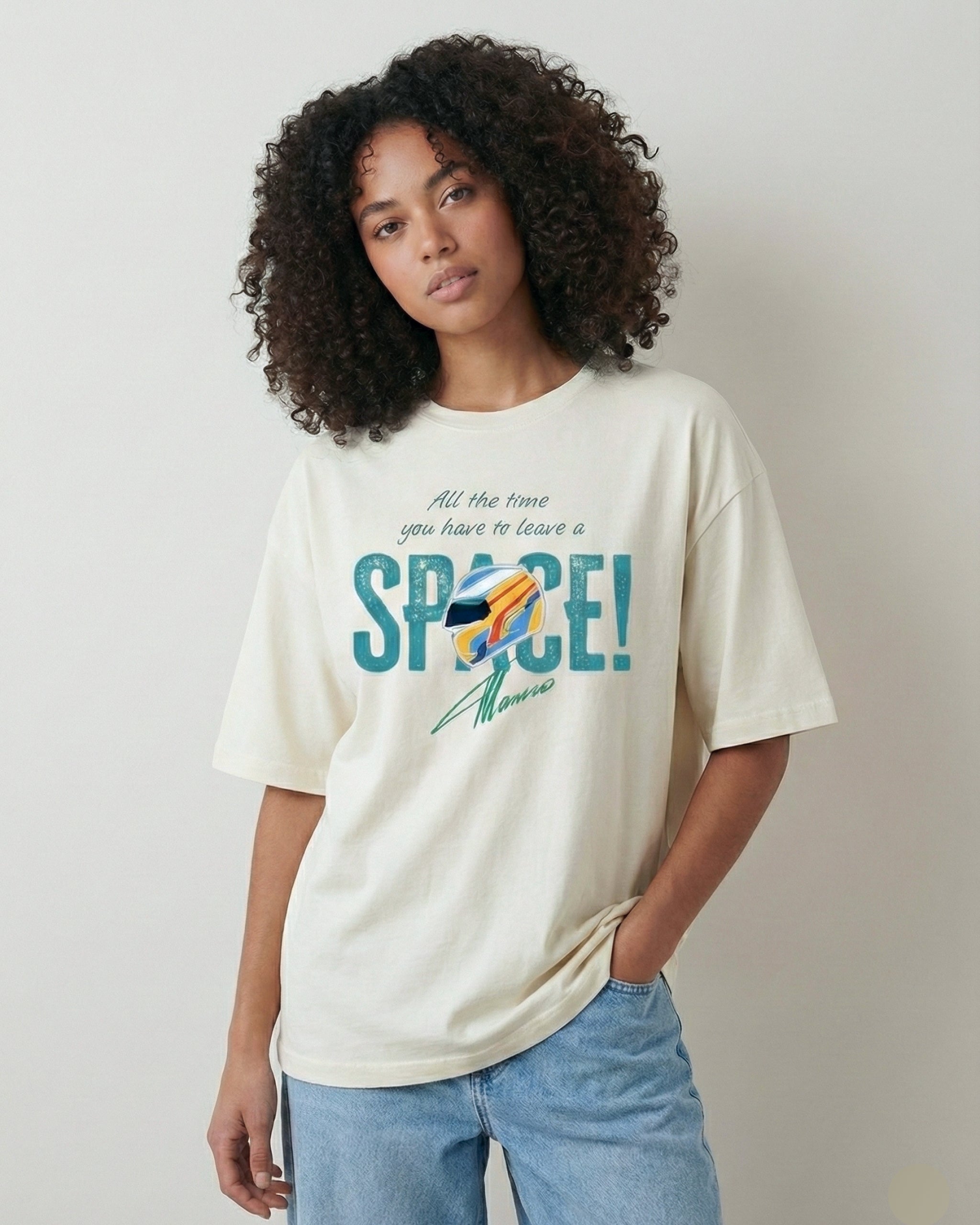 Female model wearing Off White oversized unisex F1 tshirt by Turn 1, an F1 apparel brand in India - fan graphic tee of Fernando Alonso, ex Mclaren Racing and Scuderia Ferrari F1 driver. Tshirt's front print features Fernando Alonso's signature, helmet and his famous quote "All the time you have to leave a space". 