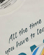 Closeup of crewneck T-shirt collar with black “OVERSIZED FIT” label of the Off White oversized unisex F1 tshirt by Turn 1, an F1 apparel brand in India - fan graphic tee of Fernando Alonso, ex Mclaren Racing and Scuderia Ferrari F1 driver. Tshirt's front print features Fernando Alonso's signature, helmet and his famous quote "All the time you have to leave a space". 