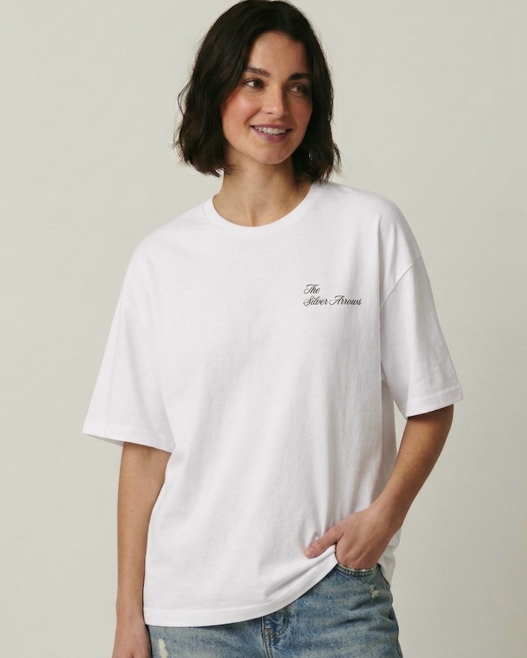 Female model wearing F1 Turn1 India Off White unisex oversized tshirt featuring Kimi Antonelli, Mercedes AMG Petronas F1 Team driver, his Mercedes F1 car and number 12.
Front print featuring text "Silver Arrows"