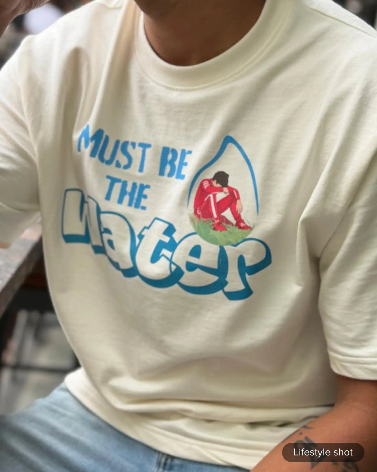 Lifestyle Image of man wearing Charles Leclerc Ferrari Formula 1 Must Be The Water Unisex Oversized F1 T-shirt Off-White | Turn1 India