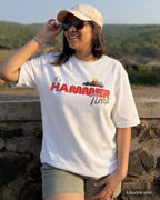 Lifestyle image of girl wearing Lewis Hamilton It's Hammertime F1 Unisex Oversized T-shirt Off-White Front View Natural Background | Turn1 India