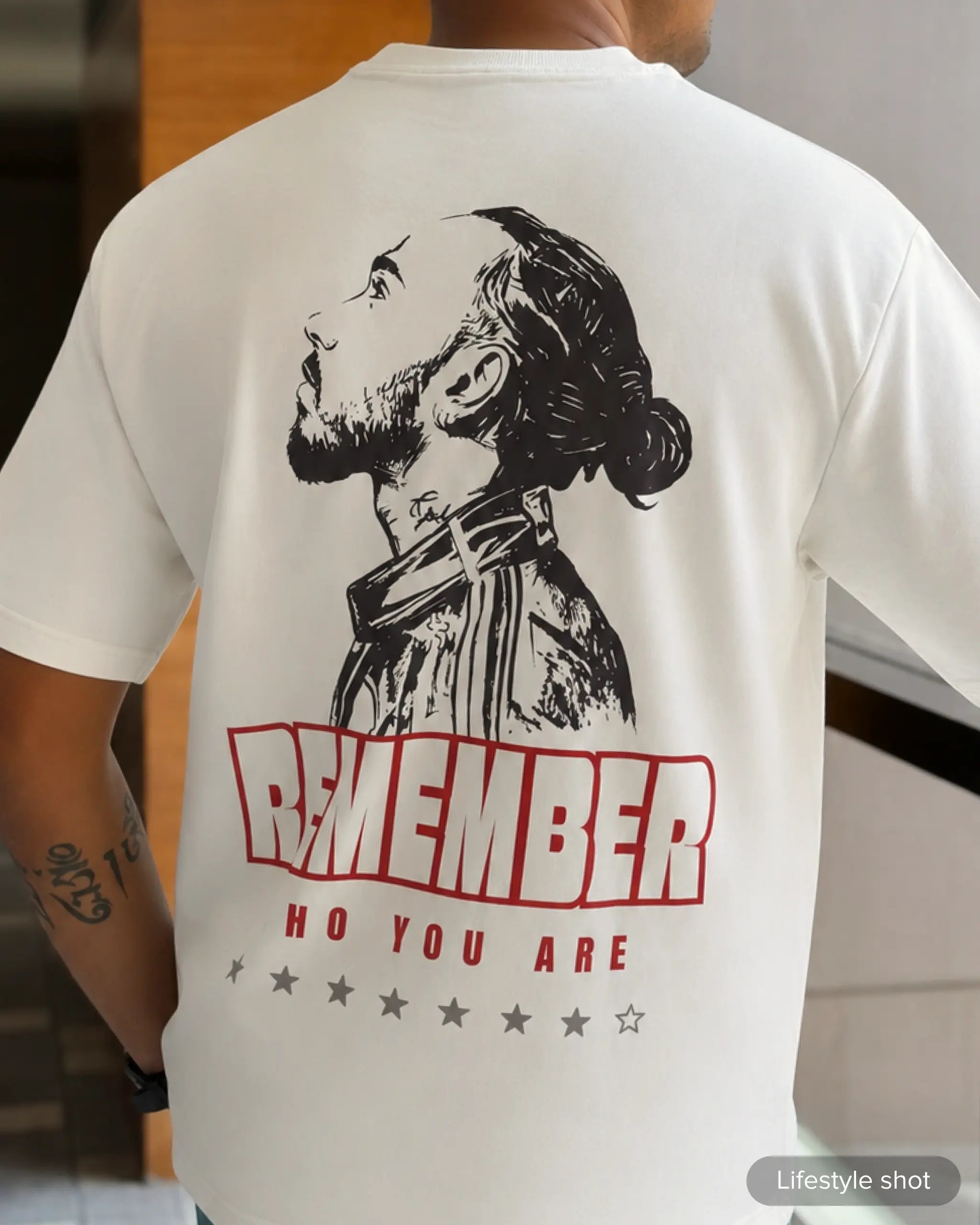Lifestyle image of man wearing Lewis Hamilton Remember Who You Are F1 Unisex Oversized T-shirt Off-White Back View | Turn1 India