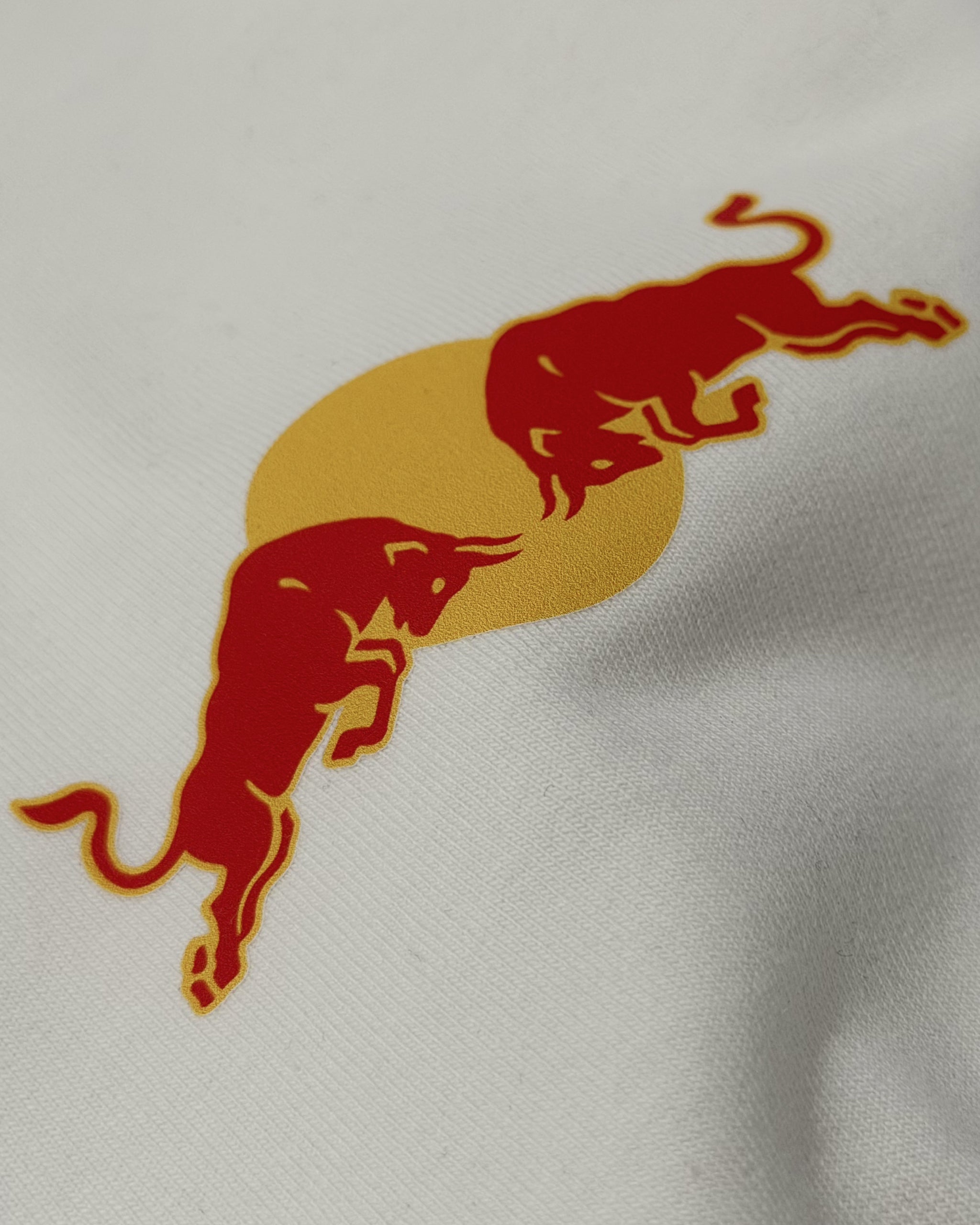 Close-up of red bull racing silhouette graphic on F1 Off White Unisex Oversized fit T-shirt by Turn 1 Brand, an F1 Apparel brand of India. Max Verrstappen fan tshirt with back print features Max Verstappen fan graphic and his name "Verstappen" in bold orange font. Frontprint features Redbull Racing F1 team logo and Max's number 3.