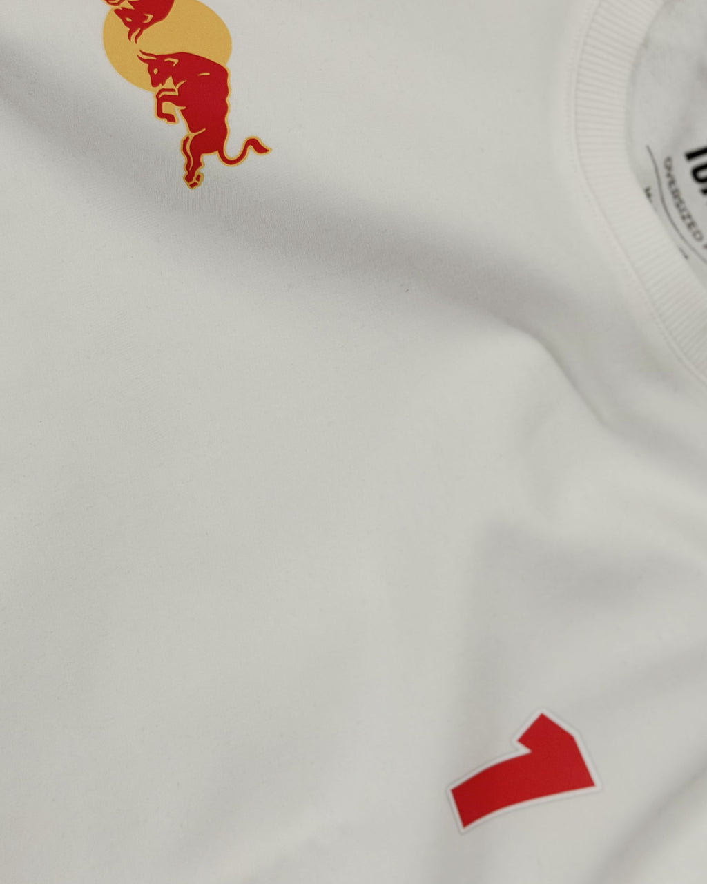 Close-up of off-white T-shirt collar on F1 Off White Unisex Oversized fit T-shirt by Turn 1 Brand, an F1 Apparel brand of India. Max Verrstappen fan tshirt with back print features Max Verstappen fan graphic and his name "Verstappen" in bold orange font. Frontprint features Redbull Racing F1 team logo and Max's number 3.