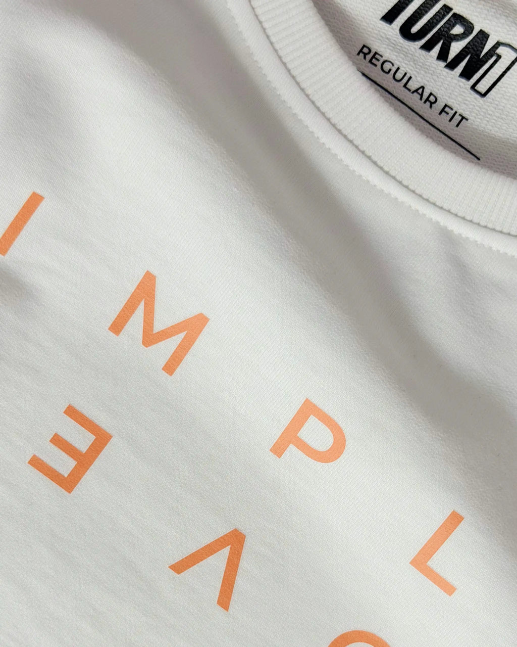 White fabric detail, orange lettering, ribbed collar with Regular Fit label on F1 White Women Crop Top by Turn 1 Brand, an F1 Apparel brand of India. Max Verrstappen fan crop top with quote "Simply Lovely" in orange font.