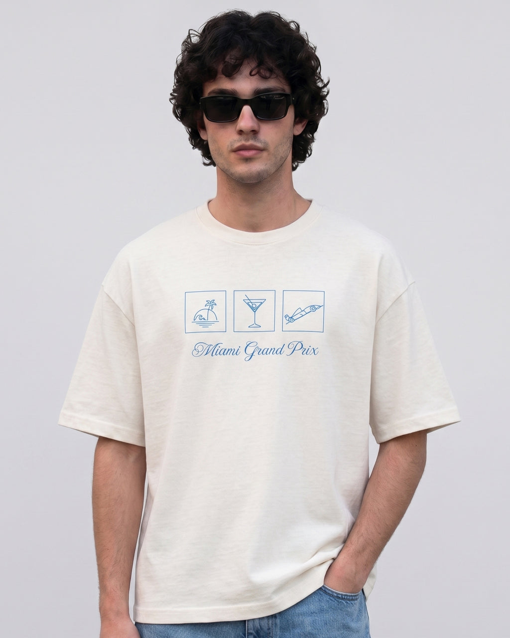 male model wearing Miami Florida USA Circuit F1 Turn1 India off white oversized unisex tshirt - with Miami circuit graphic