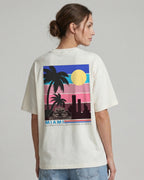 Female model wearing F1 Turn1 India Off White oversized unisex tshirt - fan graphic of Miami GP (grand prix) circuit and formula 1 car.  Miami grand prix logo on the front print
