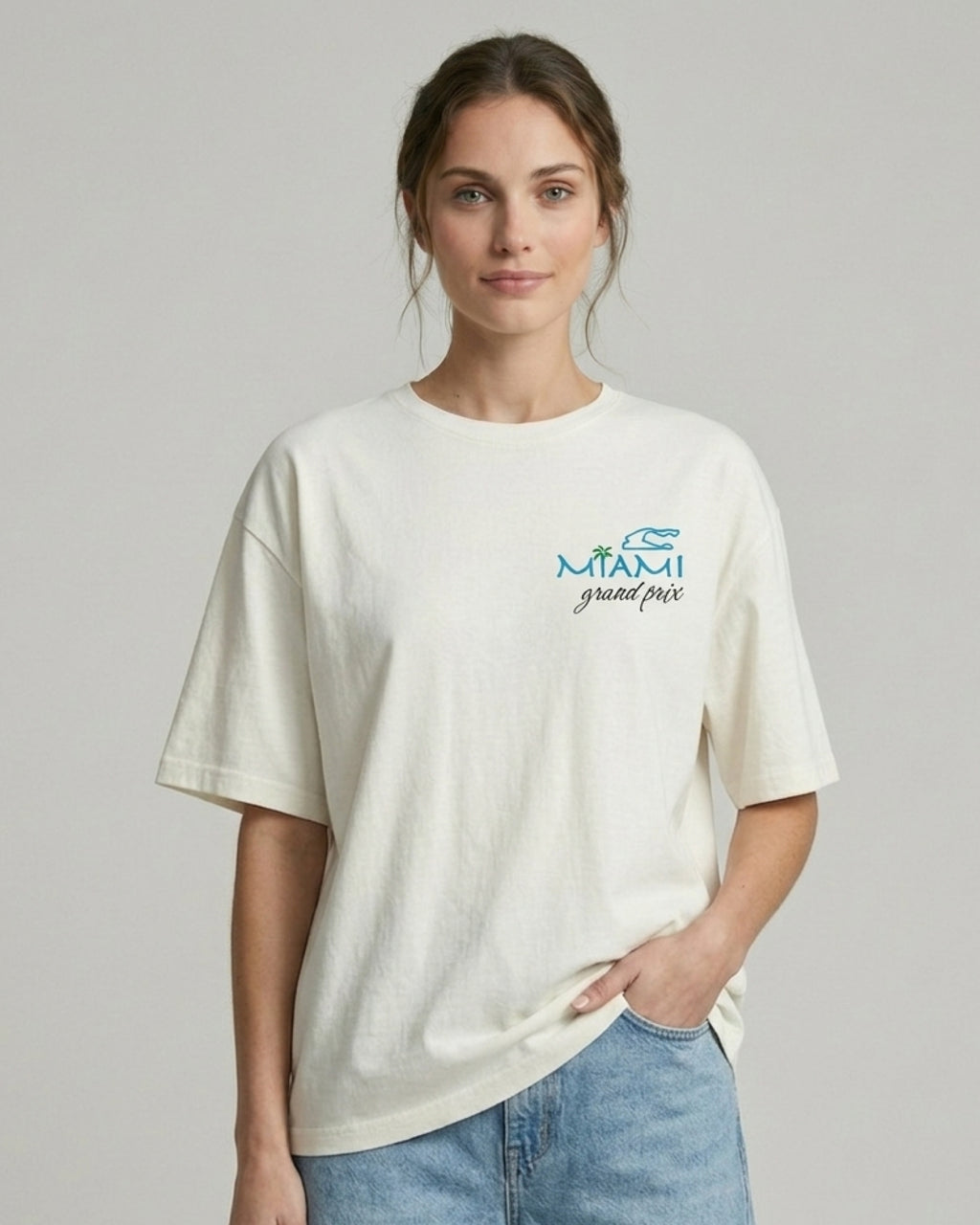 Female model wearing F1 Turn1 India Off White oversized unisex tshirt - fan graphic of Miami GP (grand prix) circuit and formula 1 car.  Miami grand prix logo on the front print