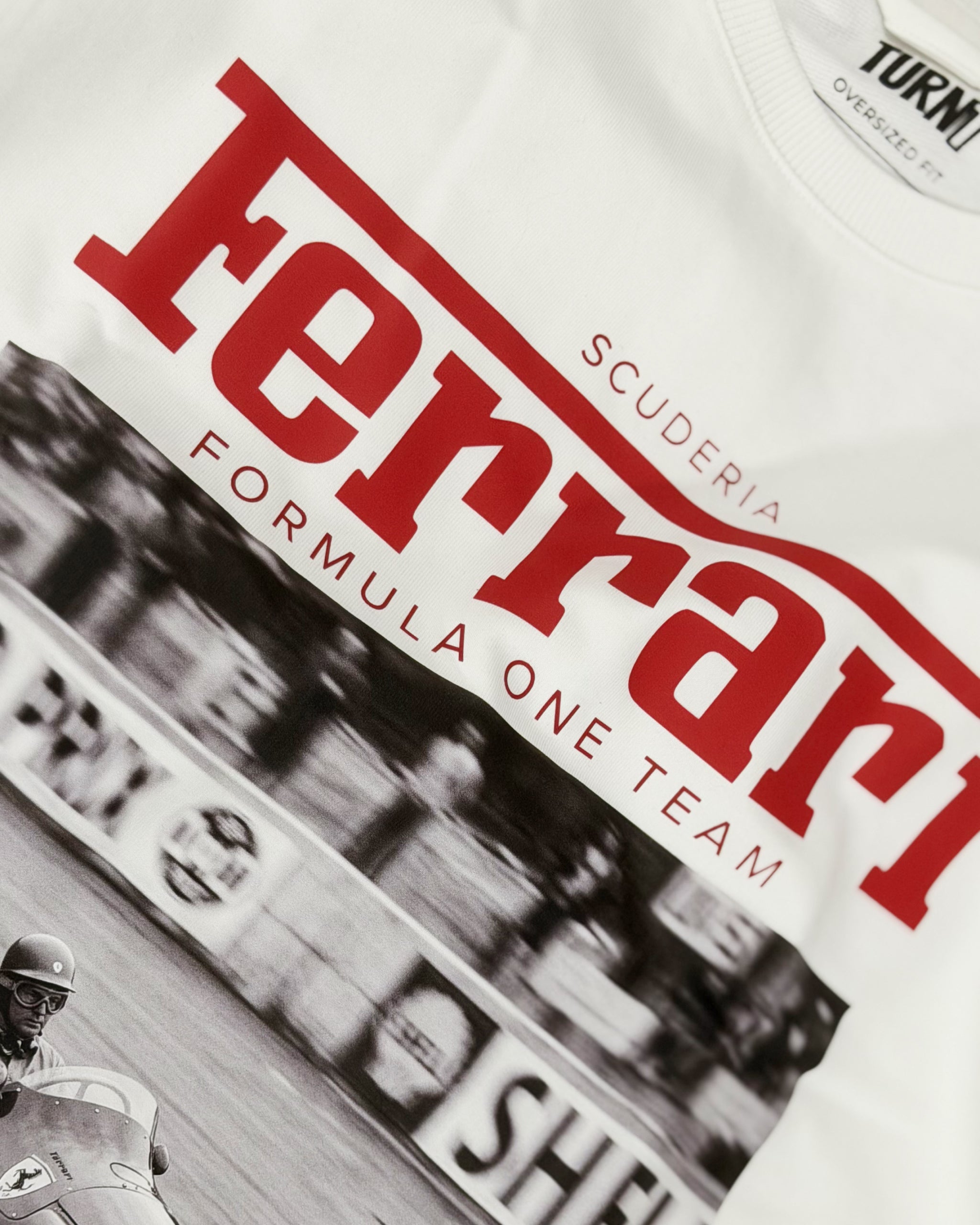 Close-up of Vintage Ferrari F1 Turn1 India off white oversized unisex tshirt - F1 Ferrari 1954 car graphic on front along with Scuderia Ferrari Formula One Team in red