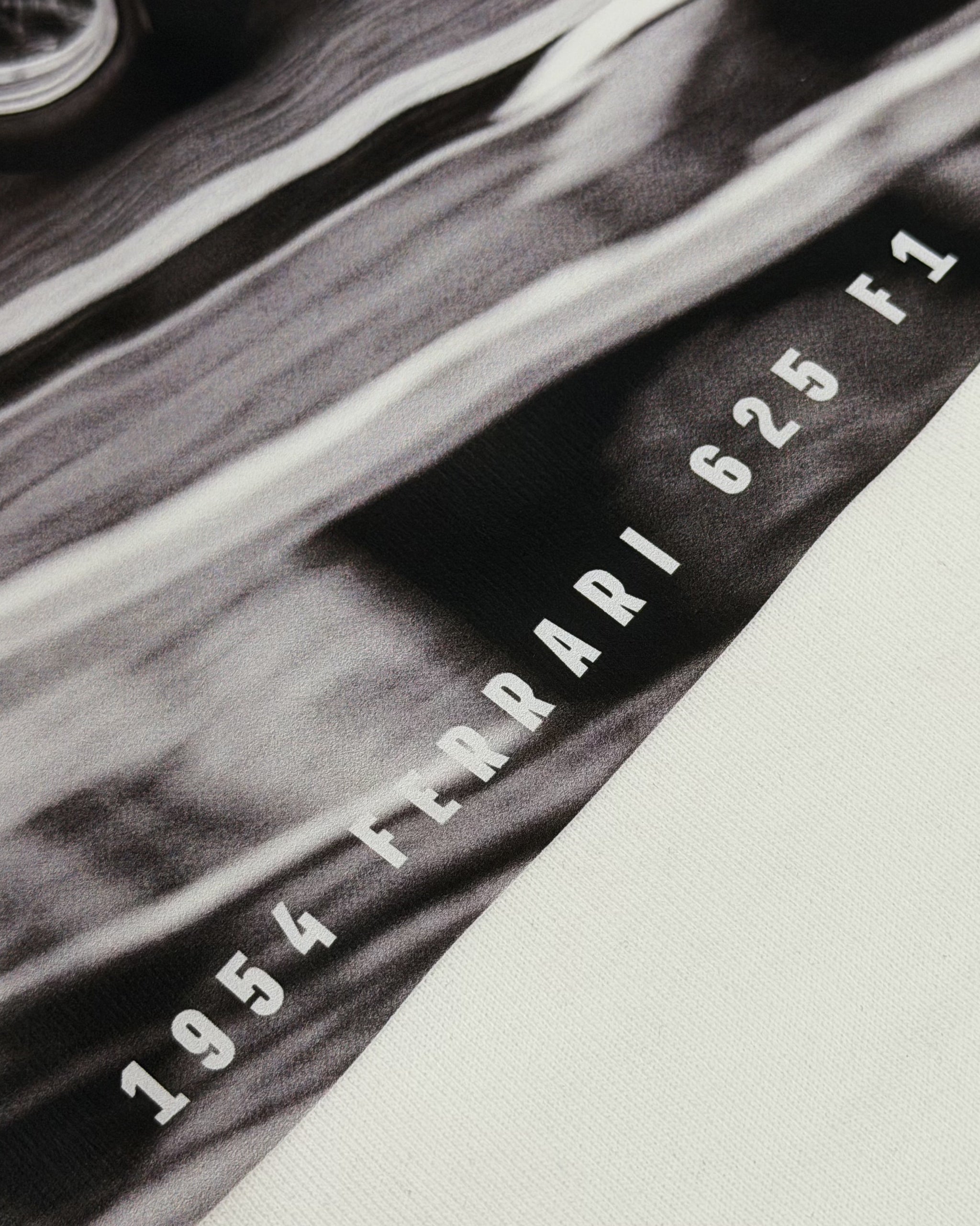 Close-up of Vintage Ferrari F1 Turn1 India off white oversized unisex tshirt - F1 Ferrari 1954 car graphic on front along with Scuderia Ferrari Formula One Team in red