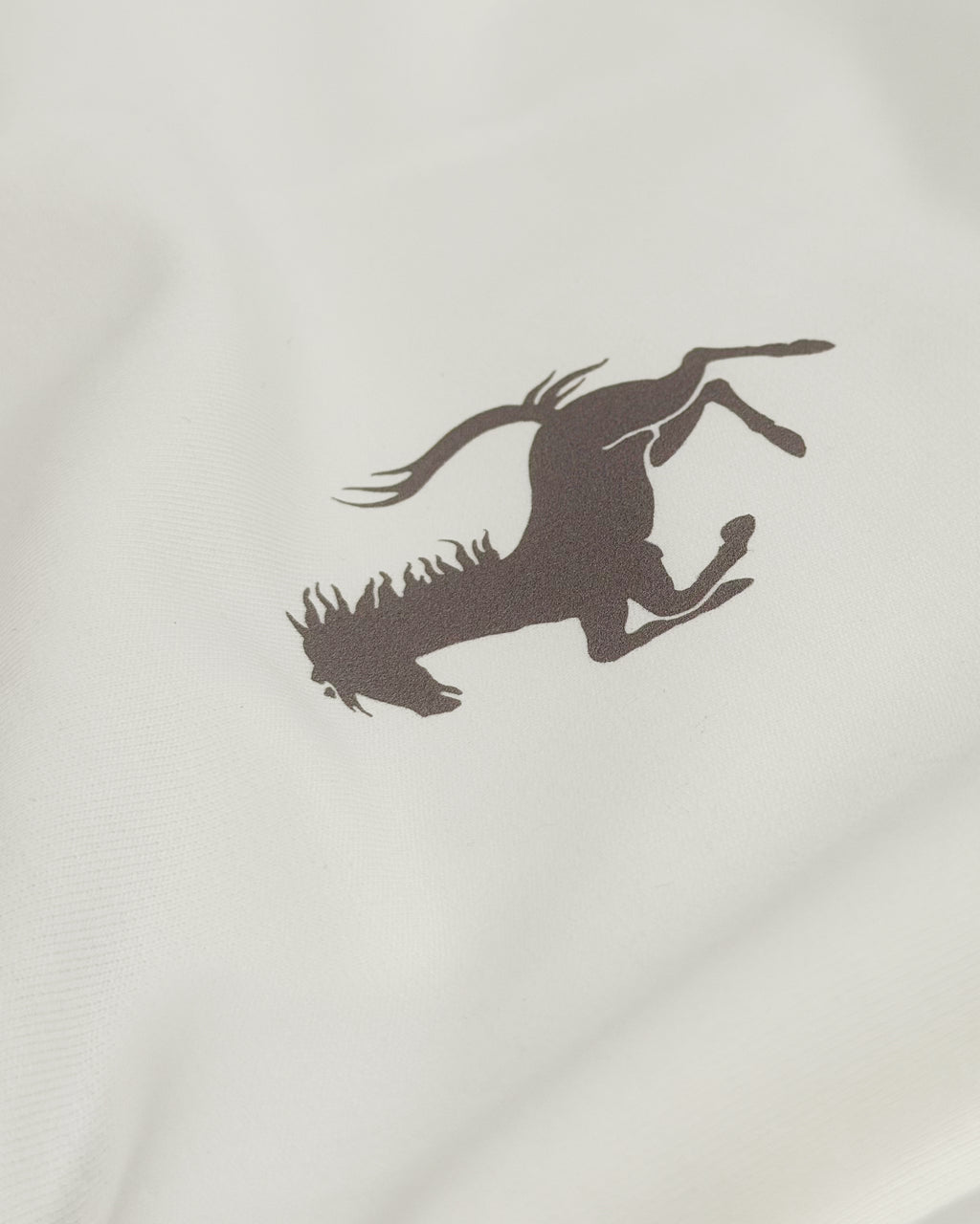Close-up of black prancing horse Ferrari emblem on Vintage Ferrari F1 Turn1 India off white oversized unisex tshirt - F1 Ferrari 1954 car graphic on front along with Scuderia Ferrari Formula One Team in red