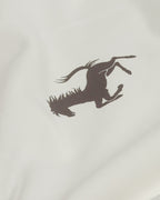 Close-up of black prancing horse Ferrari emblem on Vintage Ferrari F1 Turn1 India off white oversized unisex tshirt - F1 Ferrari 1954 car graphic on front along with Scuderia Ferrari Formula One Team in red